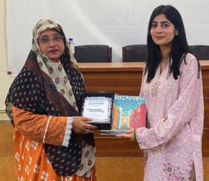 Bisma Qamar recieving award and maediaverse magazine from Dr Asmat Ara
